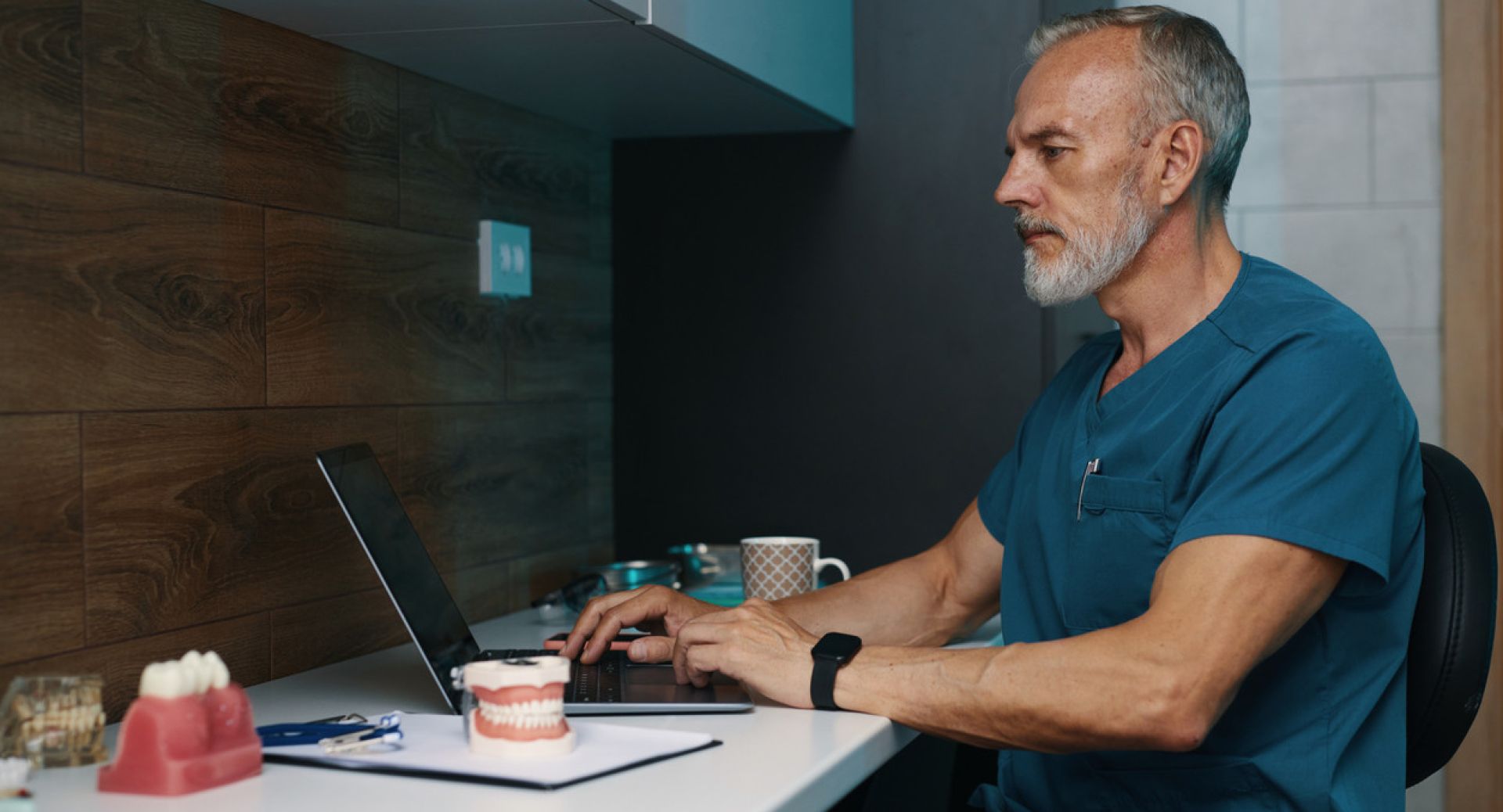 Young woman in cozy bedroom using a laptop, surrounded by stylish decor and art.
